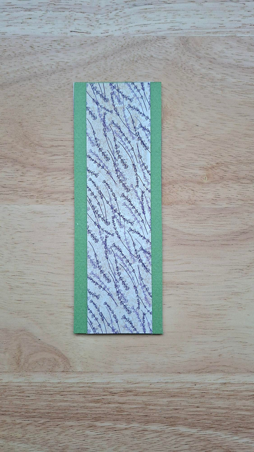 Bookmark reverse with purplish floral stems and green borders.