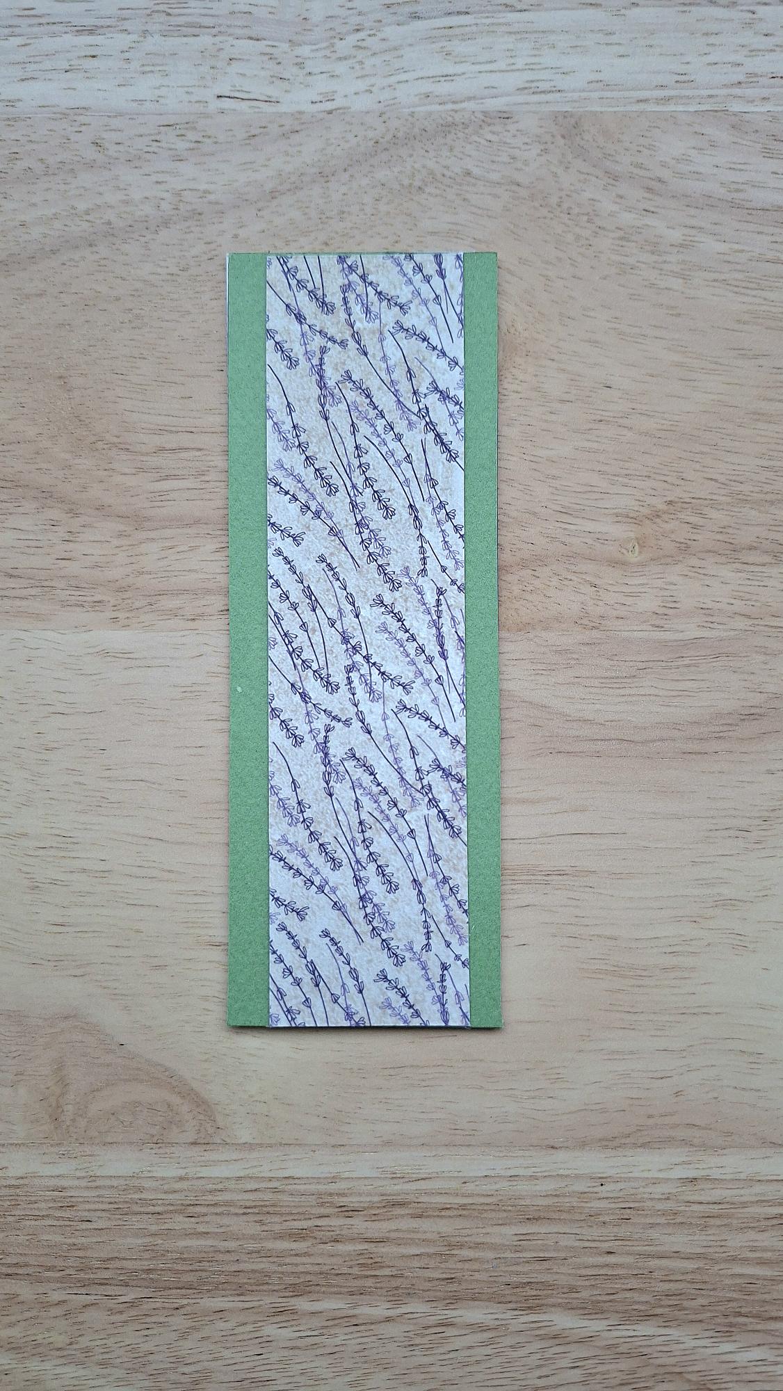 Bookmark reverse with purplish floral stems and green borders.