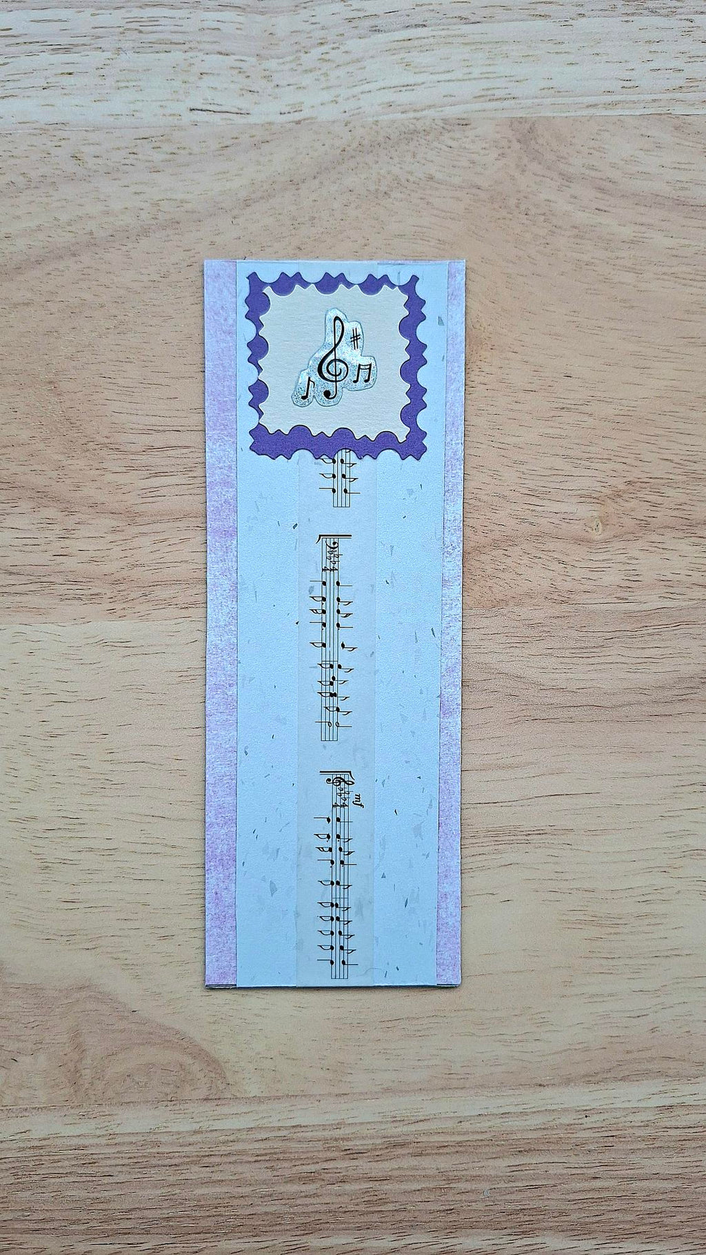 Lilac and white bookmark front with music details and purple scalloped frame.