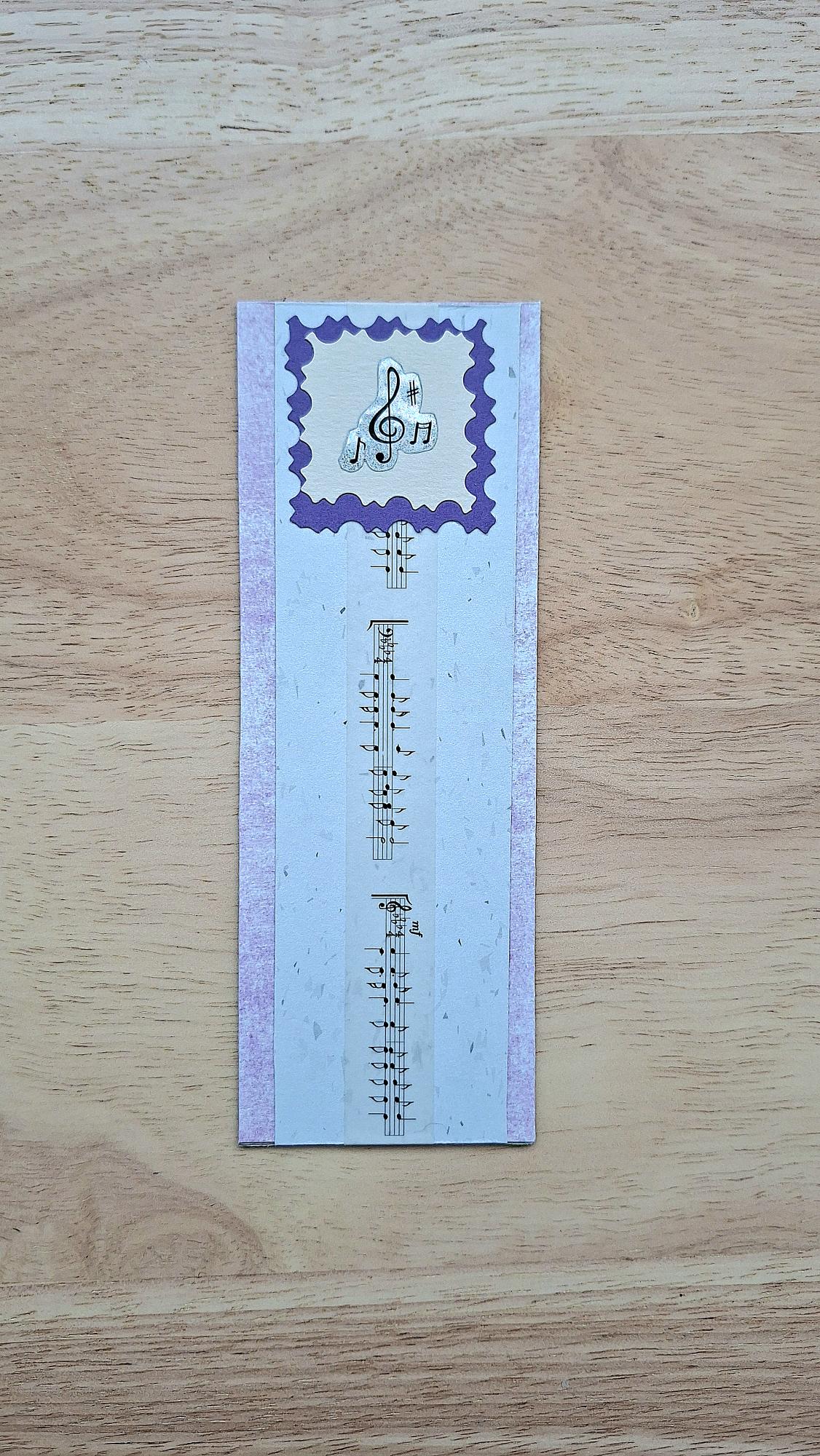 Lilac and white bookmark front with music details and purple scalloped frame.