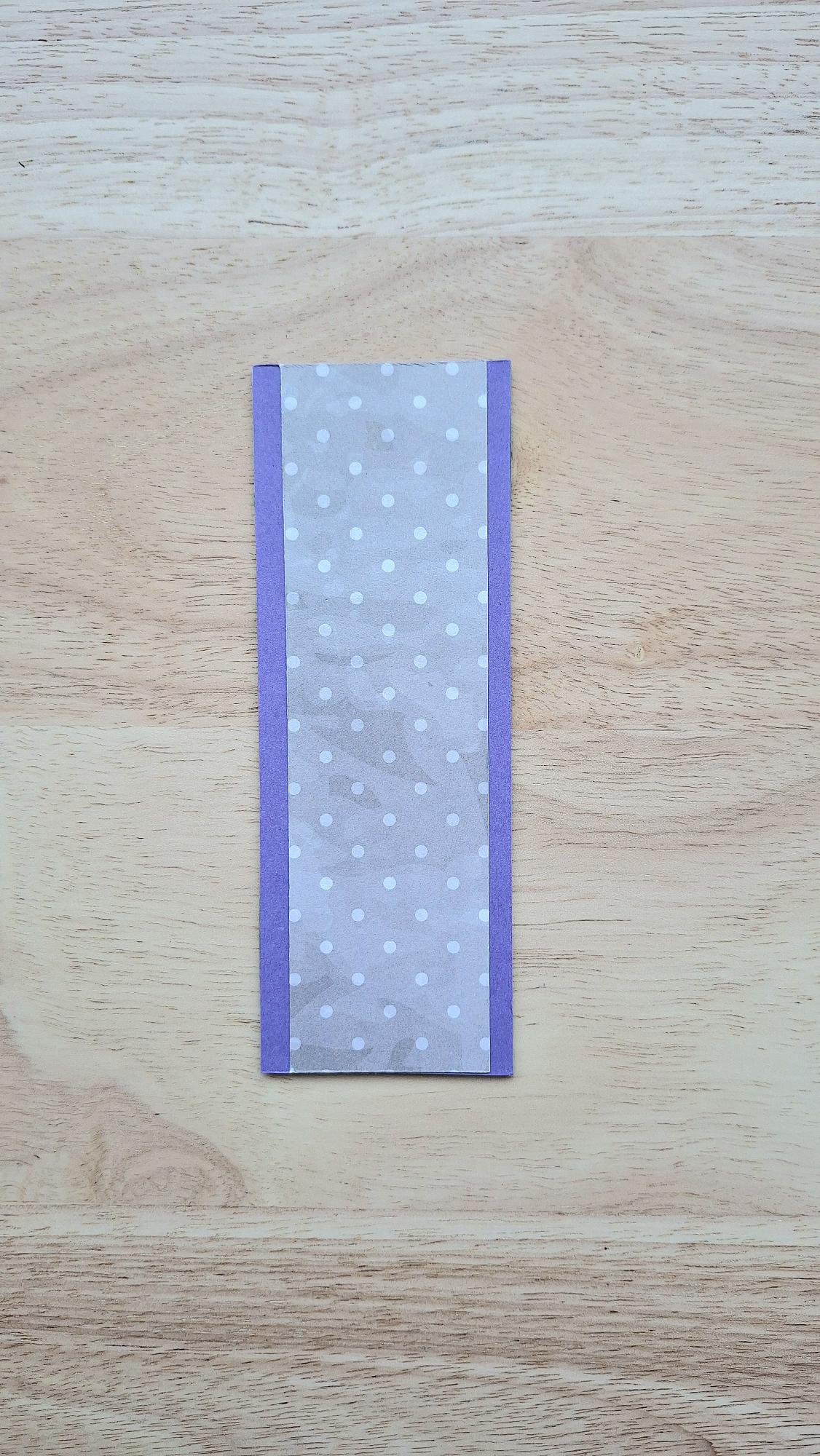 Bookmark reverse with white polka dots on soft lilac and purple borders.